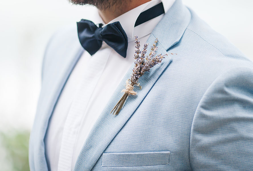 Mann mit blauem Anzug und Fliege am Hochzeitstag