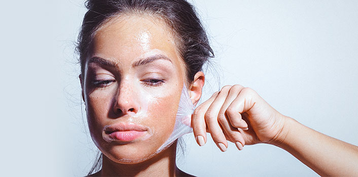 Frau nimmt eine Gesichtsmaske gegen ölige Haut ab