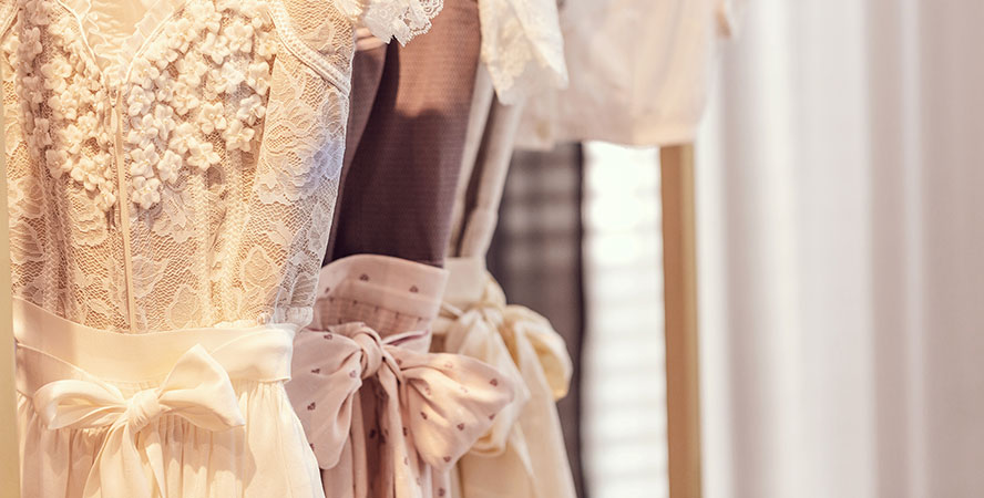 Beraterin begrüsst Braut im privaten Raum mit Standesamtkleidern