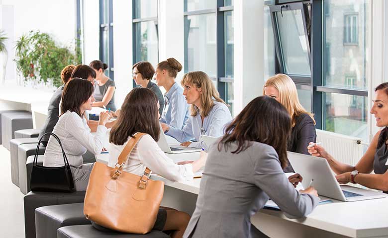 Women In Business Insights - Ein Gruppe von Frauen im Meetingraum