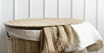 Wäschekorb aus Bast mit verschiedenen Textilien