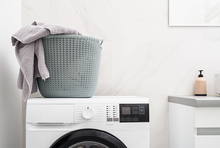 Handtuch in einem Waschkorb auf einer Waschmaschine im Badezimmer