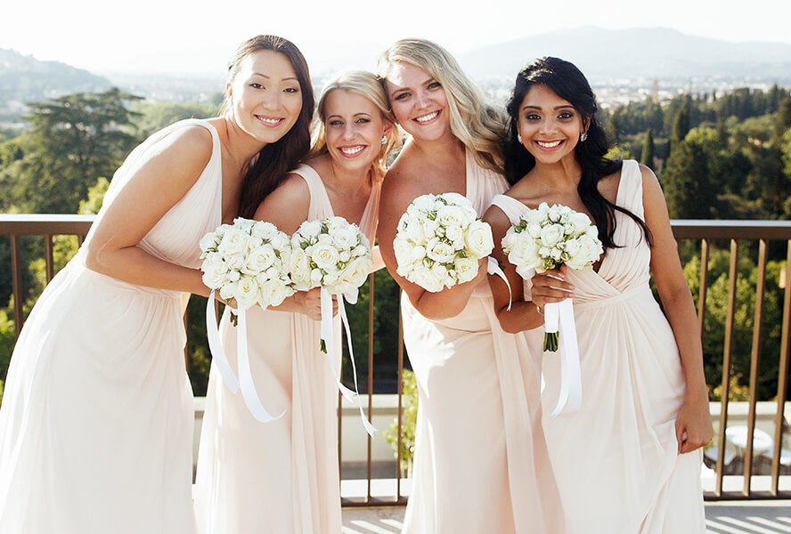 Braut mit Brautjungfern tragen lange Brautjungfernkleider und Blumensträusse