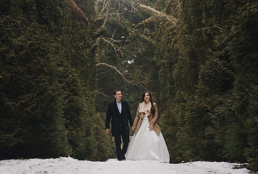 Brautpaar spaziert im verschneiten Wald