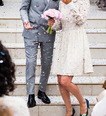 Brautpaar mit Blumen vor dem Standesamt