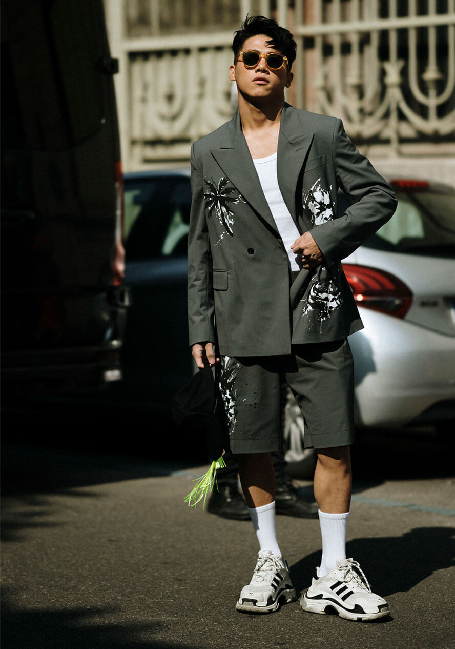 Mann trägt weiße Hybrid-Sneaker mit olivfarbenem Zweiteiler