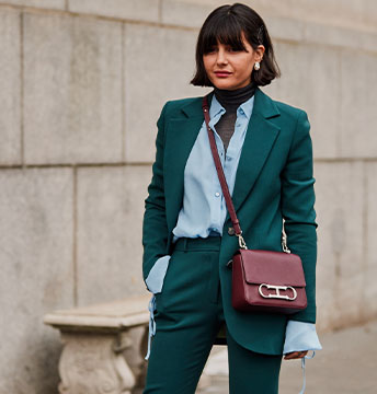 Elegante Dame, blauer Anzug, hohe weiße Schuhe und moderne Tasche