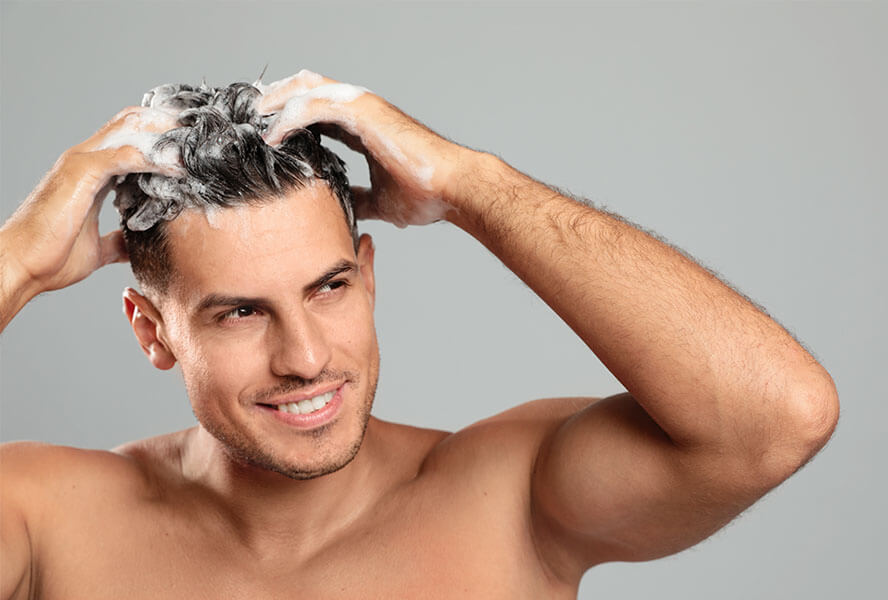 Mann schamponiert sich die Haare