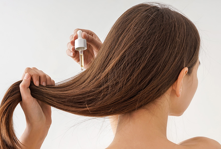 Frau benutzt Haaröl für ihre Haare