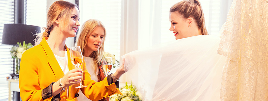 Zukünftige Braut mit Freundin bei Hochzeitskleid-Beratung