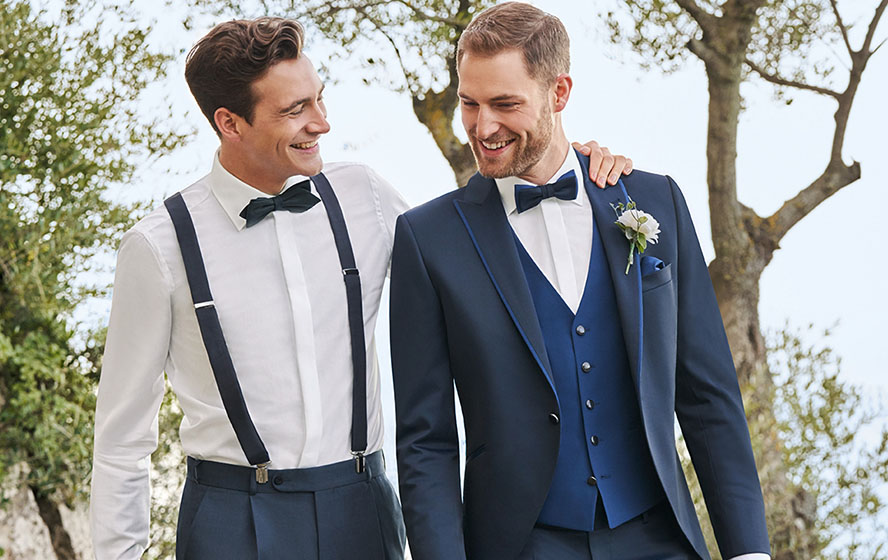 Zwei Männer in Hochzeitsanzügen mit Einstecktuch und Fliege
