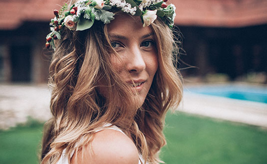 Frau trägt auf Hochzeit Blumenkranz im Haar