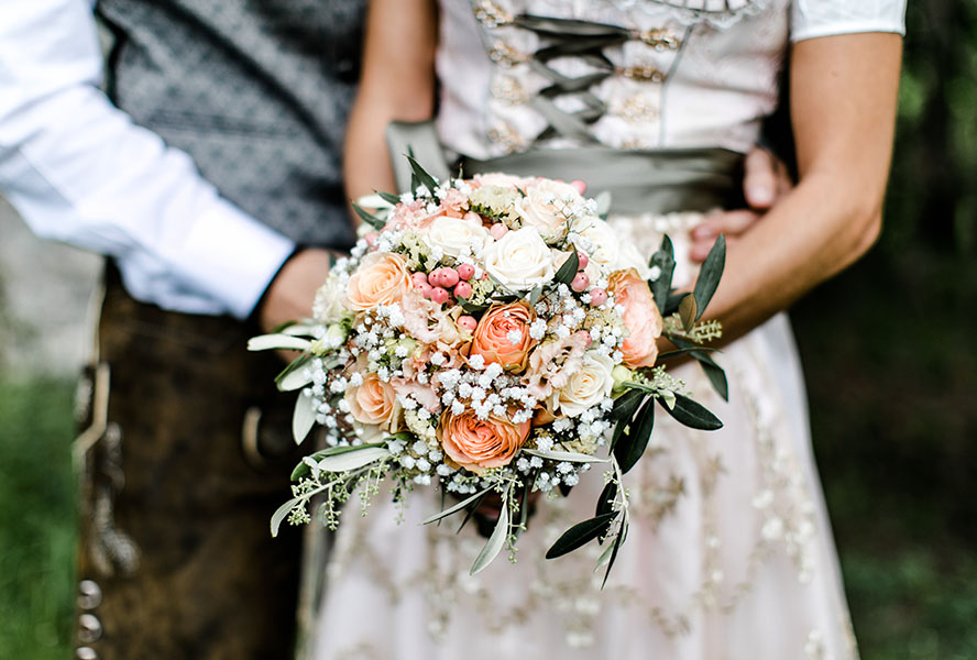 Braut im Dirndl mit Blumenstrauss