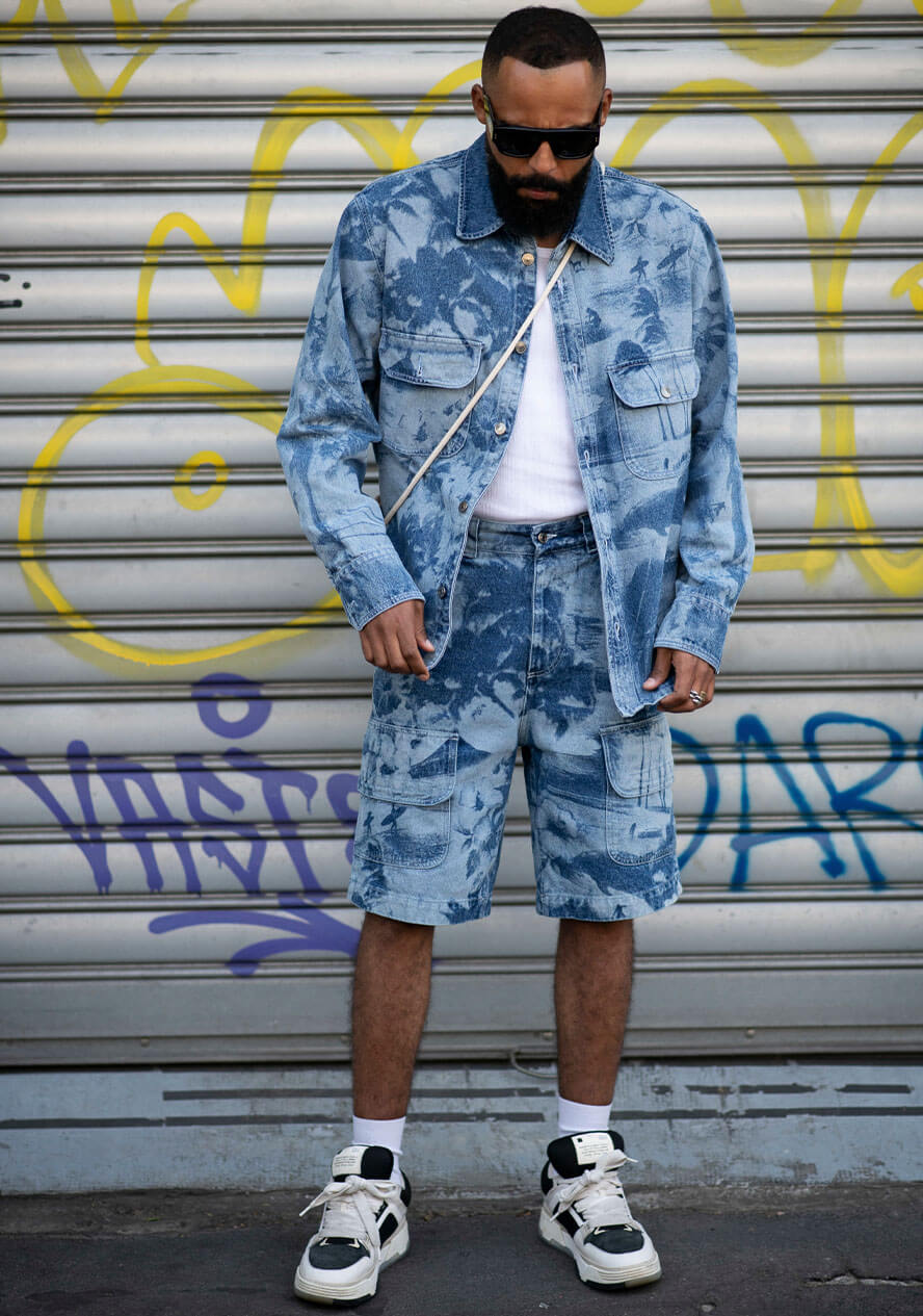 Mann trägt Jeansjacke und Jeansshorts mit Acid-Waschung