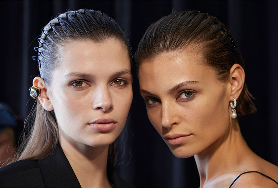 Zwei Frauen tragen auffälligen Ohrschmuck und ein natürliches Make-up