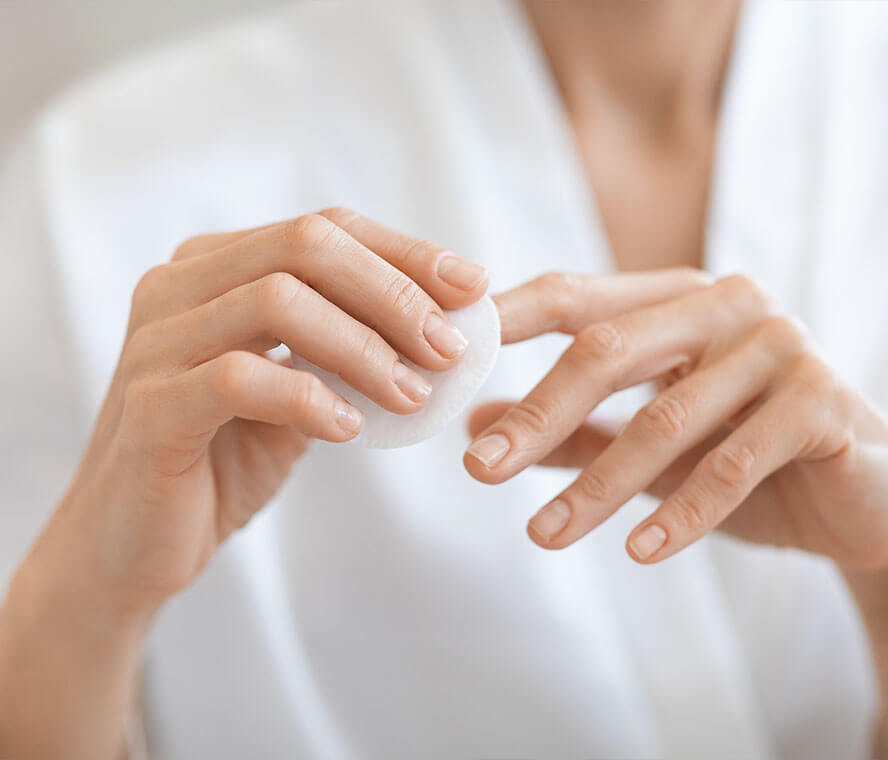 Frau lackiert sich Ihre Nägel mit einem Wattepad ab
