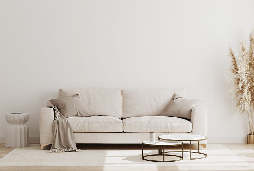 Cremefarbene Couch mit Decke, Beistelltisch und Pampasgras