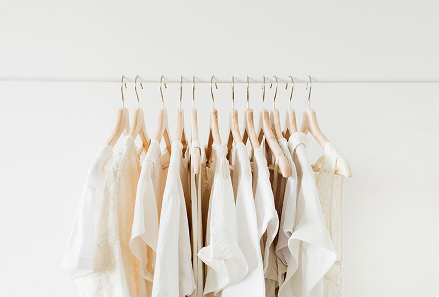 Weisse Kleidungsstücke auf einer Kleiderstange