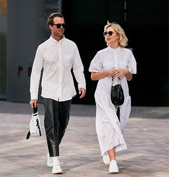 Elegant gekleidetes Paar mit weissen Sneakern in der Stadt