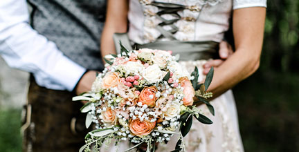Nahaufnahme Hochzeits-Dirndl mit Blumenstrauß