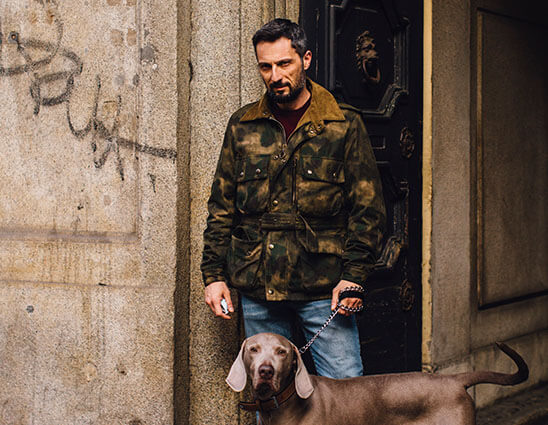 Mann in Fieldjacket mit Camouflagemuster und Hund