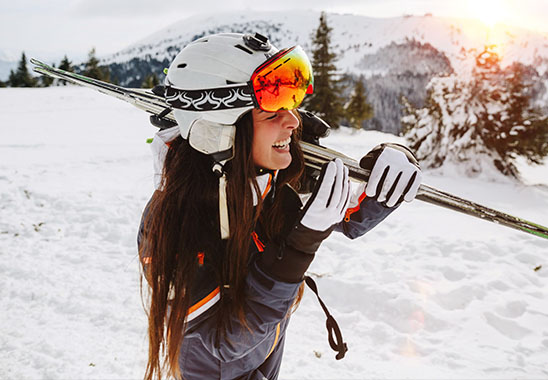 Frau mit Skiern auf der Piste